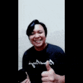a man giving a thumbs up wearing a shirt that says egool