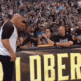 a man is standing in front of a crowd in a stadium .