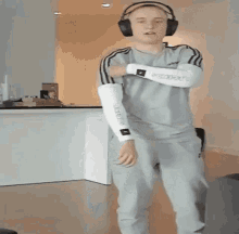 a man is wearing headphones and dancing in a living room .