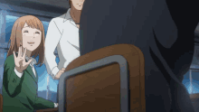 a girl sitting at a desk giving a high five to another girl