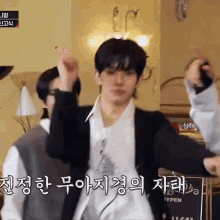 a man in a suit is dancing in a room while another man watches .