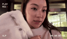 a woman in a white fur coat is being recorded