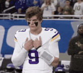 a football player wearing a purple and white jersey with the number 9 on it .
