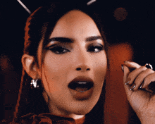 a close up of a woman 's face with a microphone in her hand