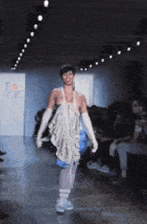 a model walks down the runway at a fashion show in front of a sign that says " i love ny "