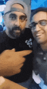 two men are posing for a picture and one of them is wearing a shirt that says ' daddy ' on it