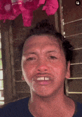 a close up of a man 's face with a blue shirt on