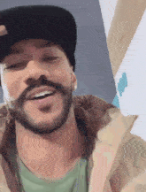 a man with a beard wearing a hat is smiling