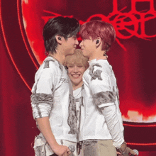 a man wearing a shirt that says peace on it kisses another man on the cheek
