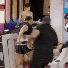 a woman in a bikini is standing next to a man in boxing gloves