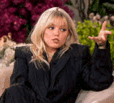 a woman in a black jacket is sitting on a couch
