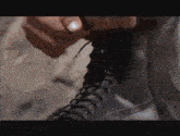 a close up of a person tying a boot .