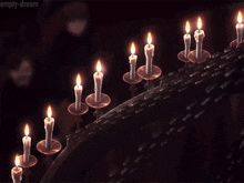 a bunch of lit candles with the words empty-dream on the bottom right