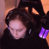 a woman wearing headphones is sitting in a chair with a microphone .