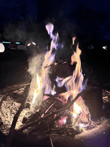 a campfire is lit up in the dark with a blue flame