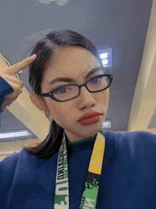 a woman wearing glasses has a lanyard around her neck that says i break
