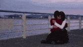 a couple hugging on a dock with a sign that says ' no smoking ' on it