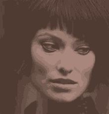 a close up of a woman 's face in a black and white photo with a fringe .