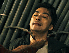 a close up of a man 's face with a worm in his mouth