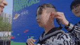 a woman with a shaved head stands in front of a sign that says ' music festival '