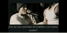 a man is singing into a microphone with the words eso es una camiseta de tirantes o un nuevo sosten