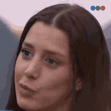 a close up of a woman 's face with a blue and green circle in the background