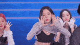a group of young women are dancing on a stage and one of them is wearing a crop top