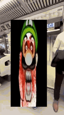 a man is walking in front of a picture of a cartoon character with blood on his face