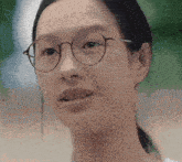a close up of a woman wearing glasses and a white shirt