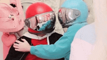 a man and a woman wearing helmets are hugging each other .