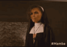 a woman in a nun costume is holding her finger to her lips while holding a microphone ..