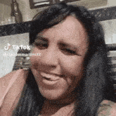 a woman is smiling and making a funny face while sitting in a chair .