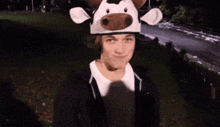 a young man wearing a cow hat makes a funny face