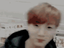 a man with red hair is looking at the camera in a blurry photo .