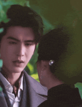 a man in a suit and tie is standing next to a woman in a hat .