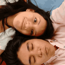 a man and a woman are laying on their heads with their eyes closed