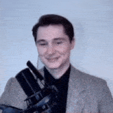 a man in a suit is smiling while holding a microphone and wearing headphones .