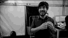 a black and white photo of a man with a beard smiling .