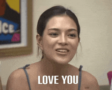 a woman says " love you " in front of a framed picture