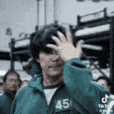 a man wearing a green jacket with the number 45 on it