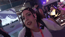 a woman taking a picture of herself in front of a sign that says twitch con