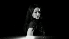 a black and white photo of a woman with long hair and a necklace that says calvin klein