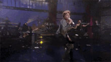 a woman is dancing on a stage in front of a crowd .