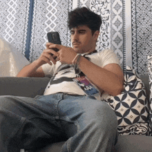 a man sits on a couch with a lanyard that says aaa on it