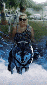 a woman standing next to a wolf with the letter m on the bottom right