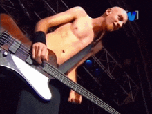 a shirtless man is playing a bass guitar in front of a tv screen that says ' v1 ' on it