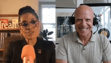 a man and a woman are sitting next to each other in front of a microphone and smiling .