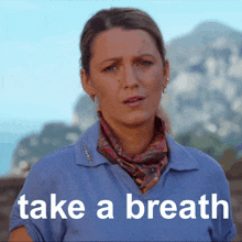 a woman wearing a scarf and a blue shirt says " take a breath "