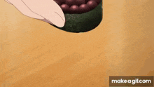 a person is holding a piece of sushi with a bunch of berries on it .