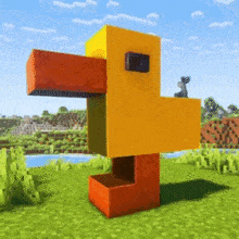 a yellow and orange duck is standing in a grassy field in a minecraft game .